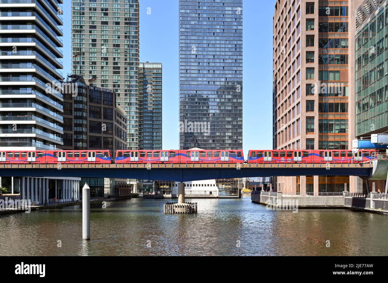 London, England - June 2022: Driverless passenger train of the Docklands Light Railway on a bridge over one of the docks in Canary Wharf Stock Photo