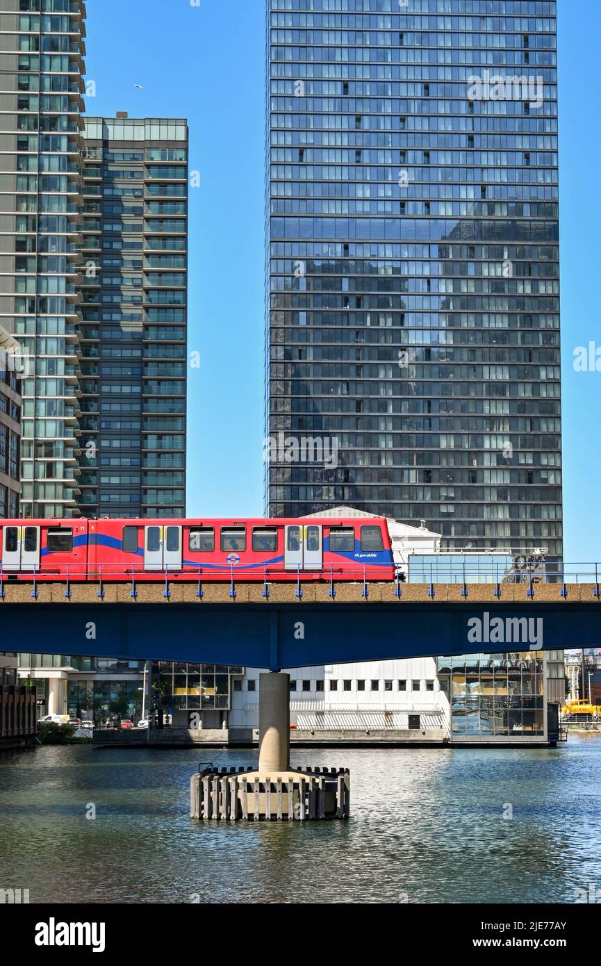 London, England - June 2022: Driverless passenger train of the Docklands Light Railway on a bridge over one of the docks in Canary Wharf Stock Photo