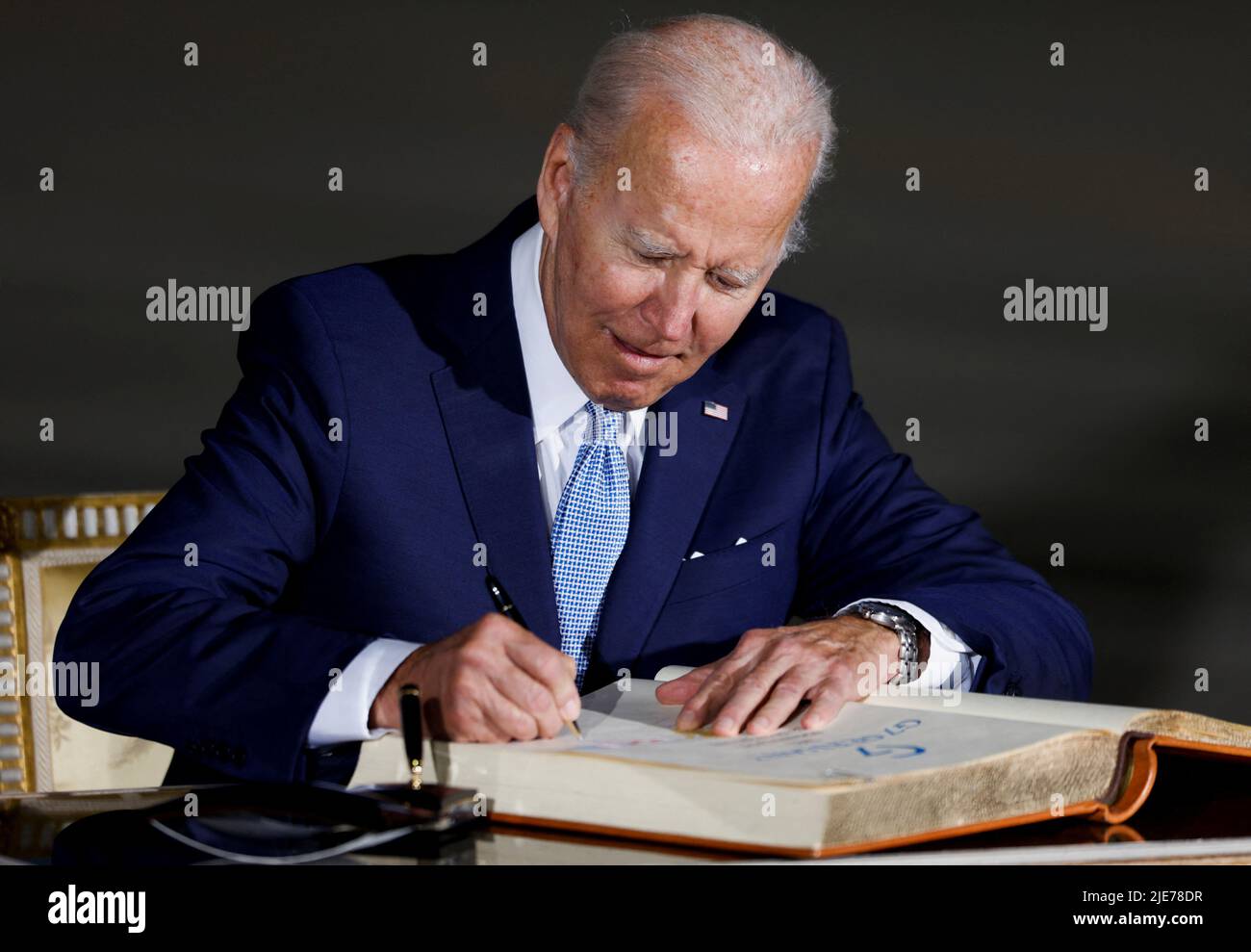 U.S. President Joe Biden signs the Golden Book of the Bavarian State government as he arrives for a G7 summit at Munich International Airport near Munich, Germany June 25, 2022. REUTERS/Michaela Rehle Stock Photo