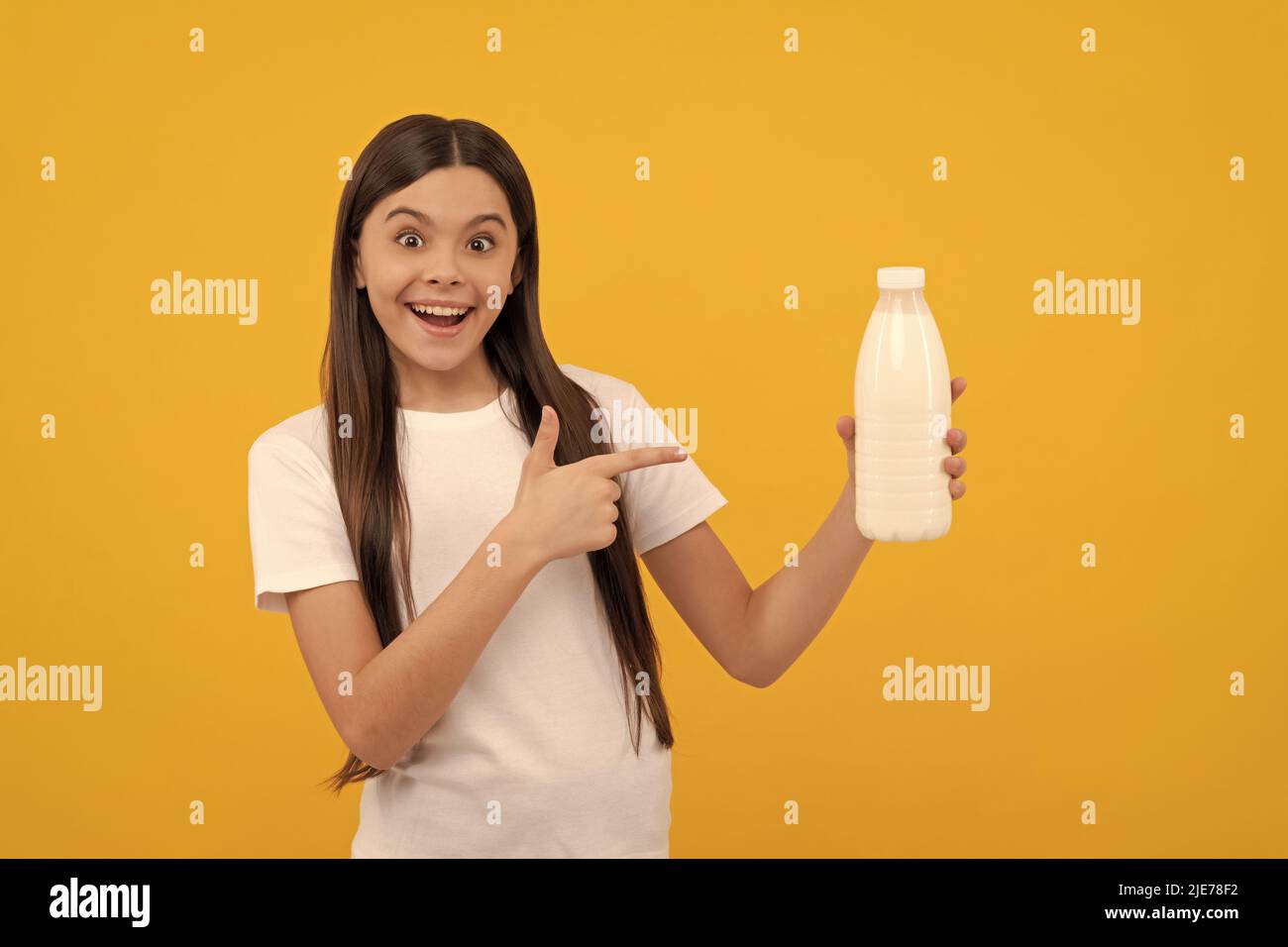 surprised child point finger on dairy beverage product. teen girl going to drink milk. Stock Photo