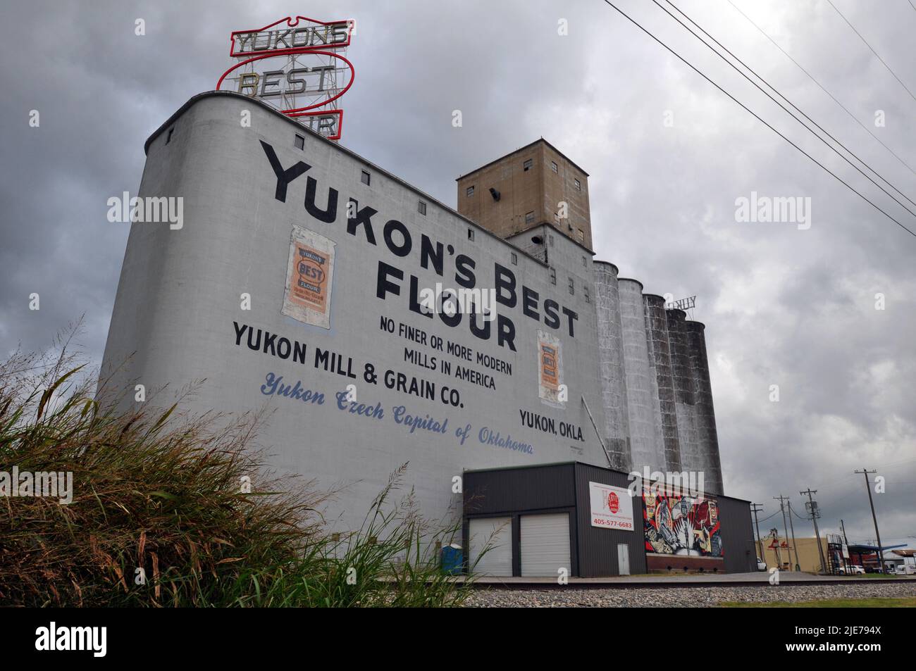 The historic Yukon Mill & Grain Company elevators stand alongside railroad tracks in the Route 66 city of Yukon, Oklahoma. Stock Photo