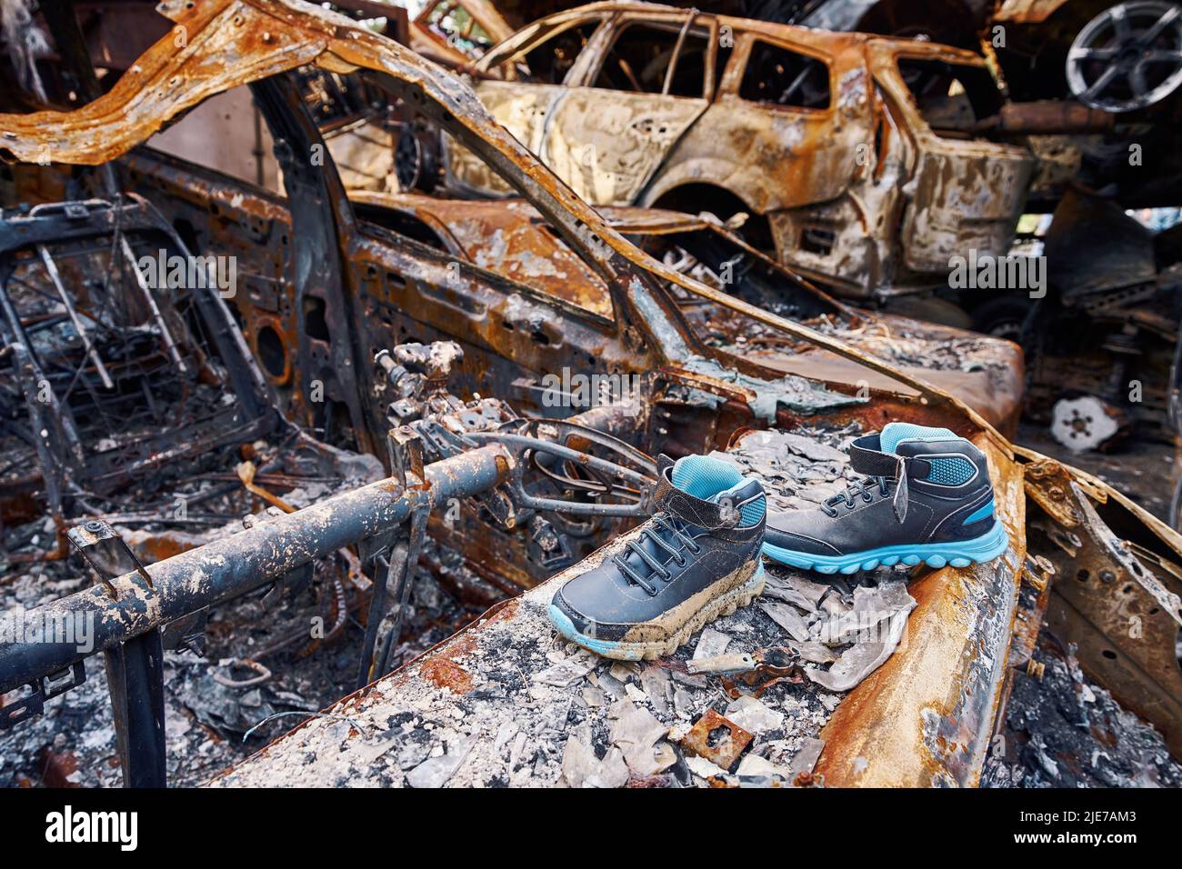 Children boots on top of destroyed car in Bucha Stock Photo