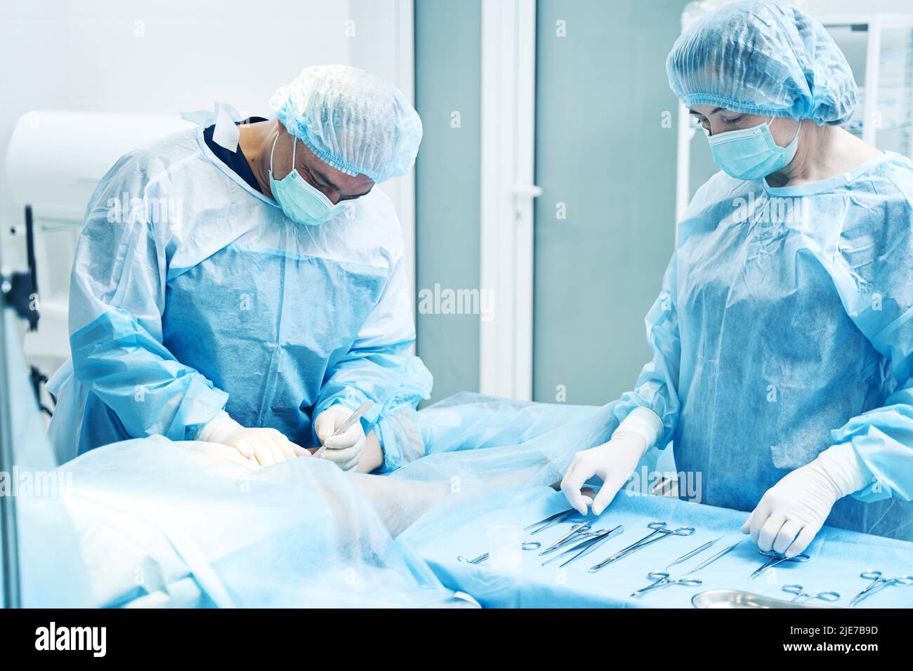 Two doctors working in the operation theatre with surgical tools Stock ...