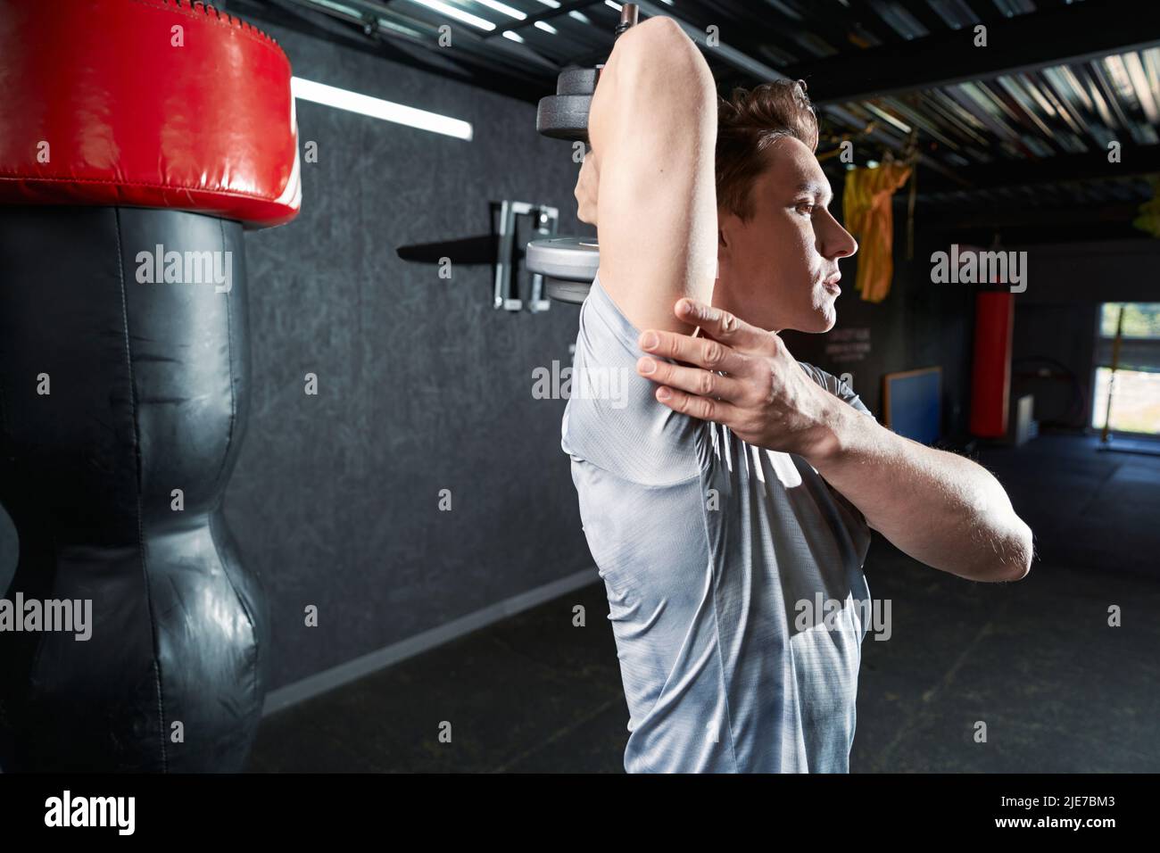 Athletic man doing strength training exercise at gym Stock Photo