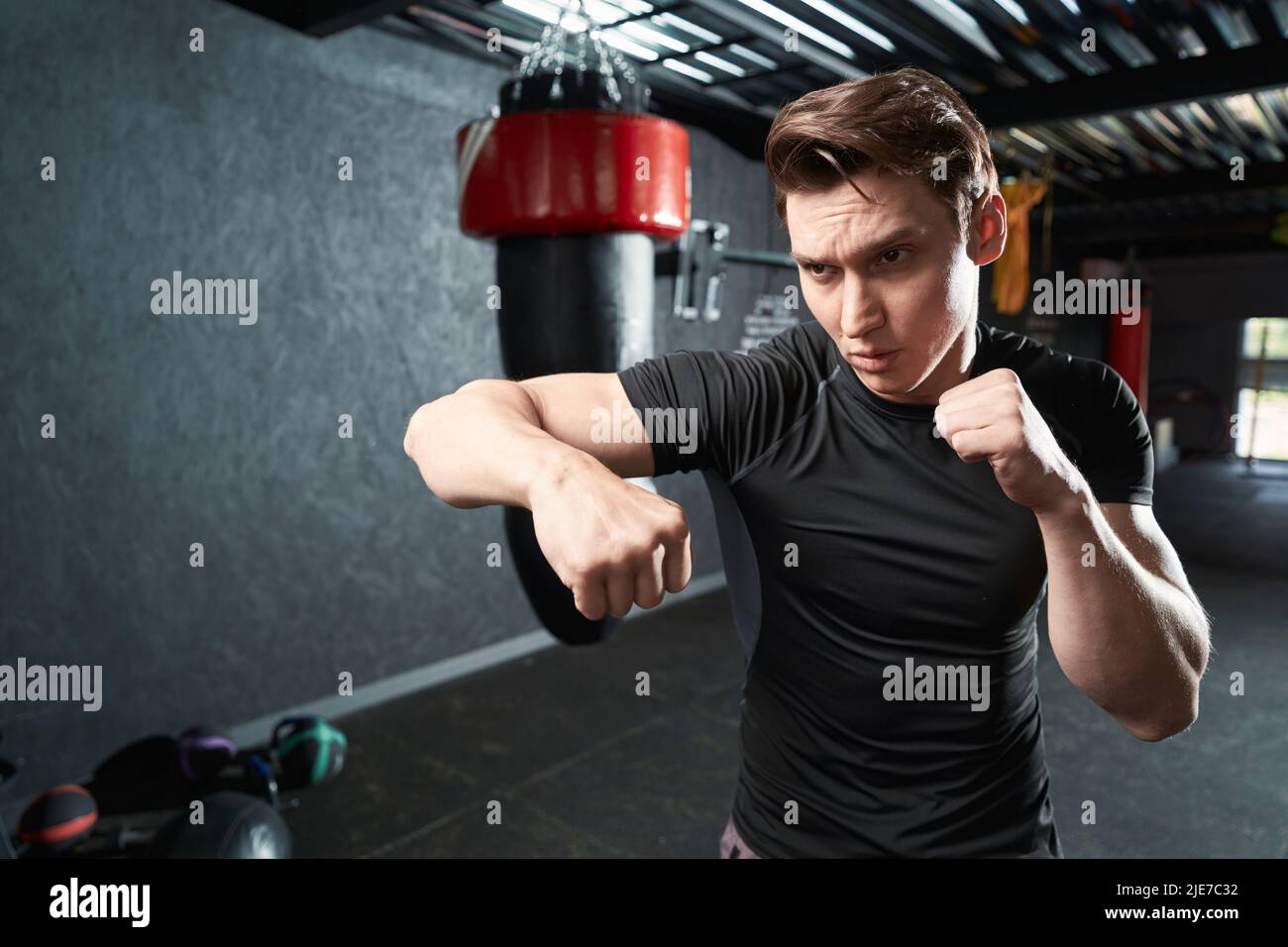 Focused young athlete shadowboxing during gym workout Stock Photo
