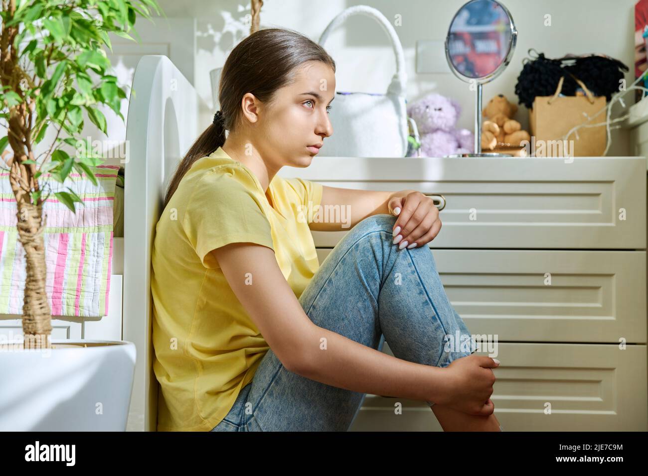 Sad teenage girl sitting on the floor at home Stock Photo - Alamy