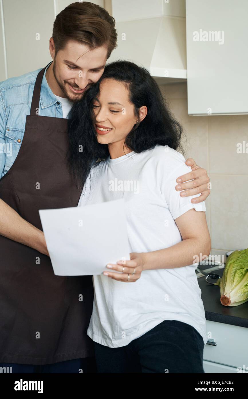 Happy young couple perusing business documentation at home Stock Photo ...