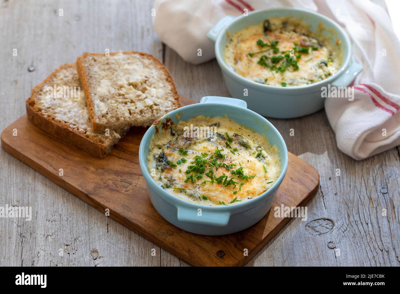 Egg baked in spinach and bechamel sauce Stock Photo