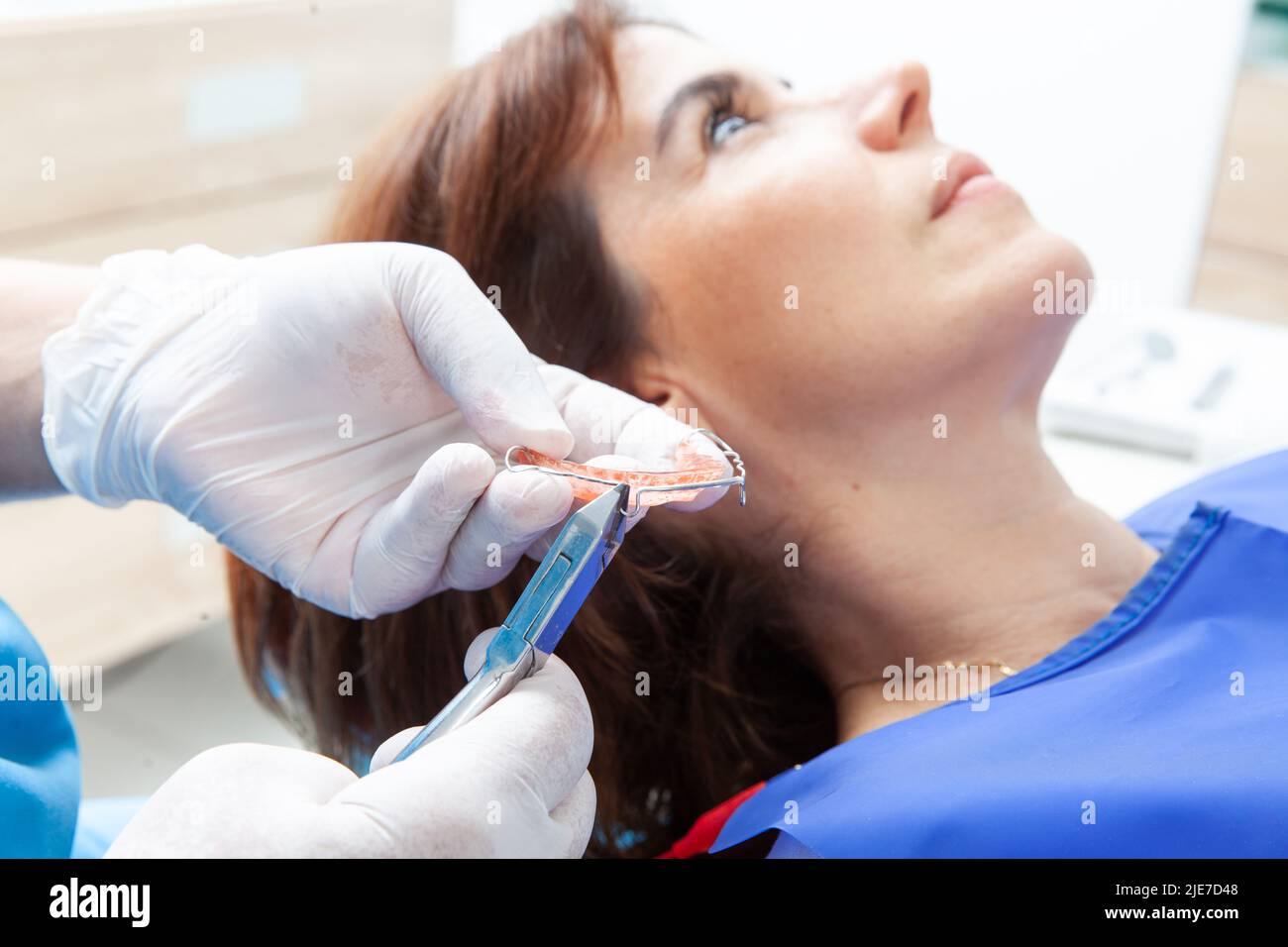 Orthodontic specialist dentist adjusting a retainer for a female