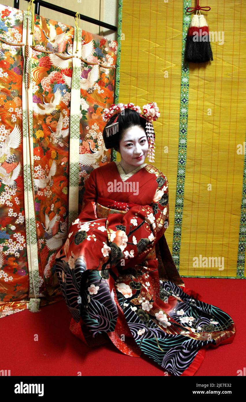 Lady dressed in traditional kimono Maiko style walking in Gion district Kyoto showing authentic accessories and styling in historic setting