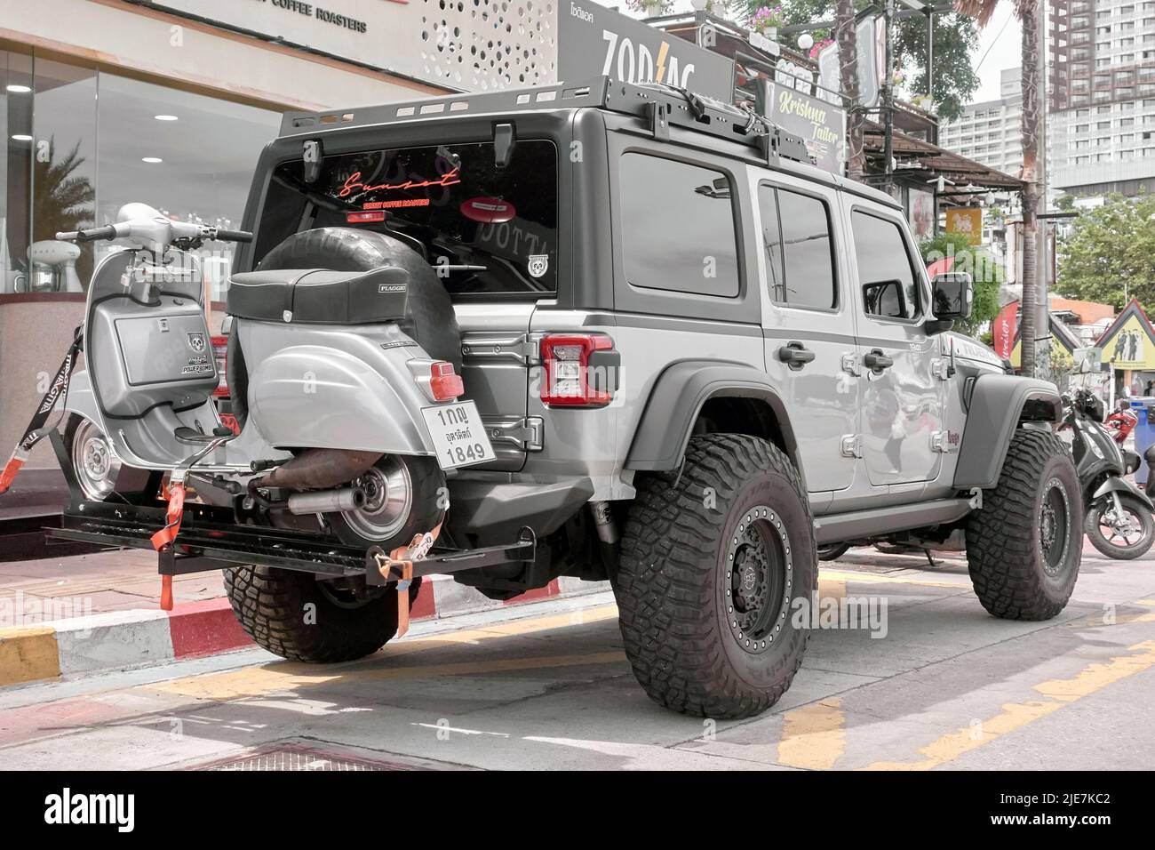 Jeep Wrangler Rubicon SUV 4 x 4 all terrain vehicle carrying a rear mounted Vespa Piaggio scooter Stock Photo