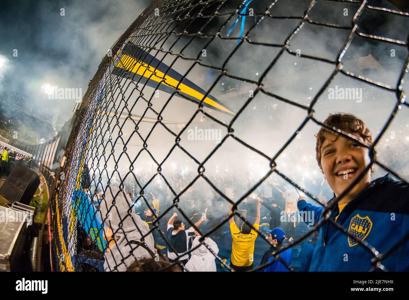 Boy holding stick of fireworks to receive the home team Boca Juniors at La Bombonera Stadium. Stock Photo