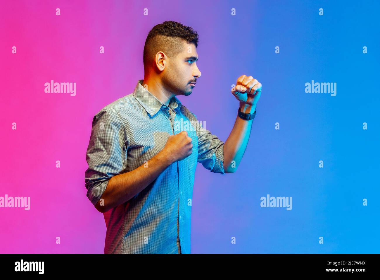 Side view portrait of young adult angry aggressive man in shirt