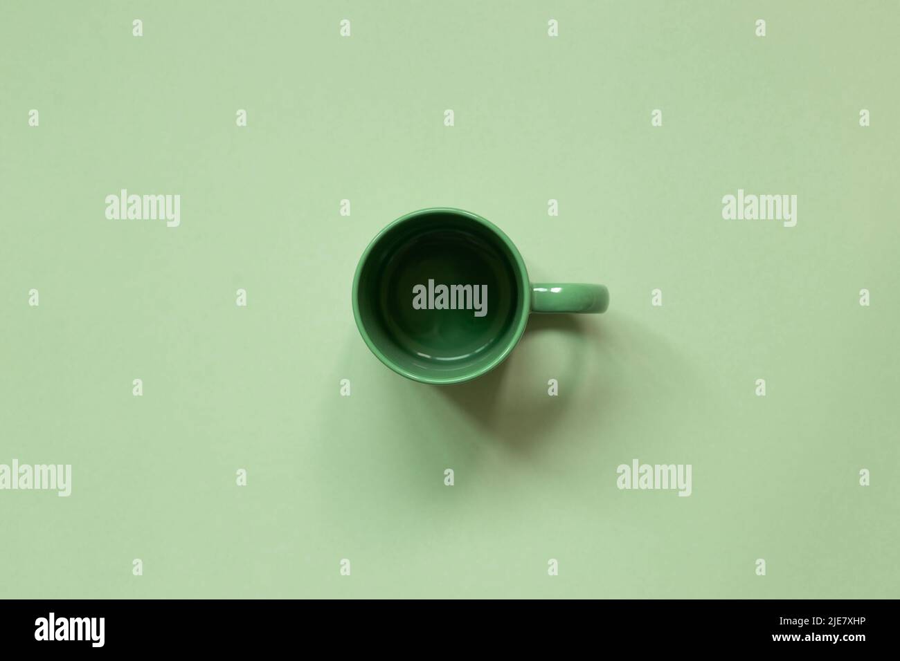 Empty mug cup on green background. top view, copy space Stock Photo