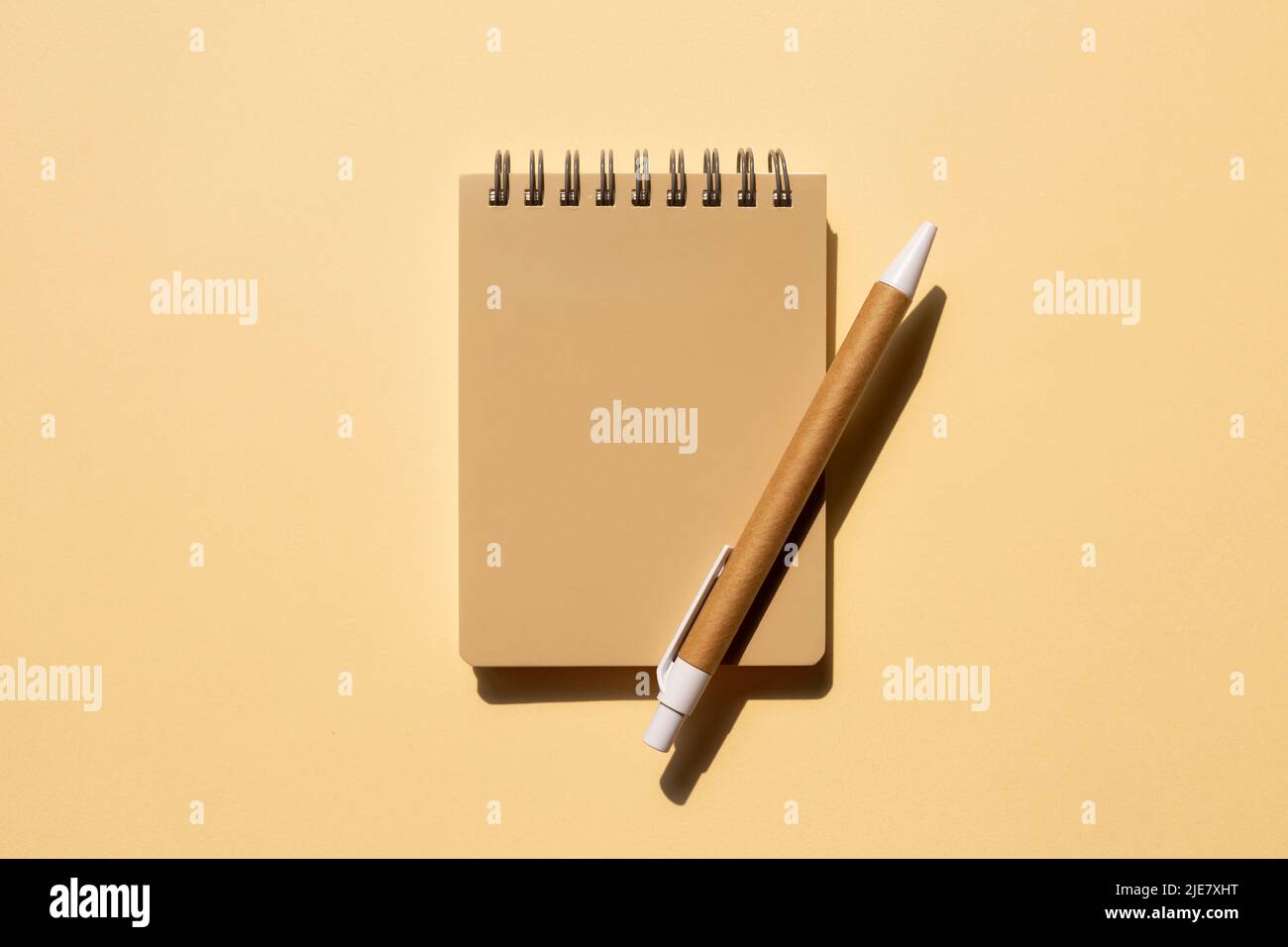 Notebook and pen on beige background. top view, copy space Stock Photo