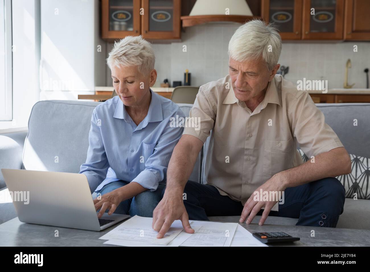 Older couple manage family budget, pay bills, sorting out papers Stock Photo