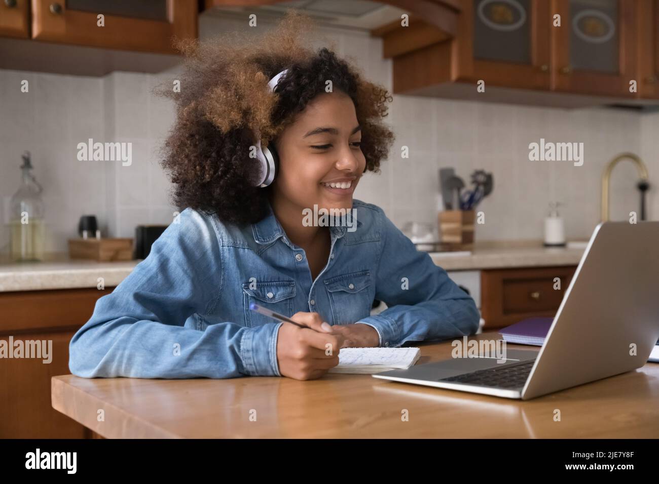 Pretty African girl wear headphones studying use laptop Stock Photo - Alamy