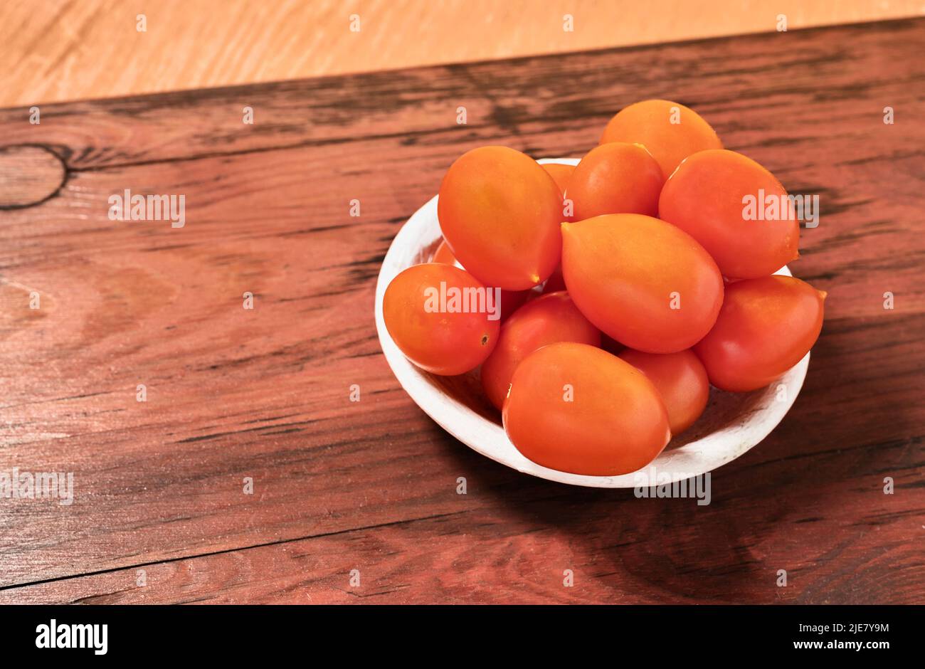 Bowl with red cherry tomatoes on wooden table ,healthy eating Stock Photo