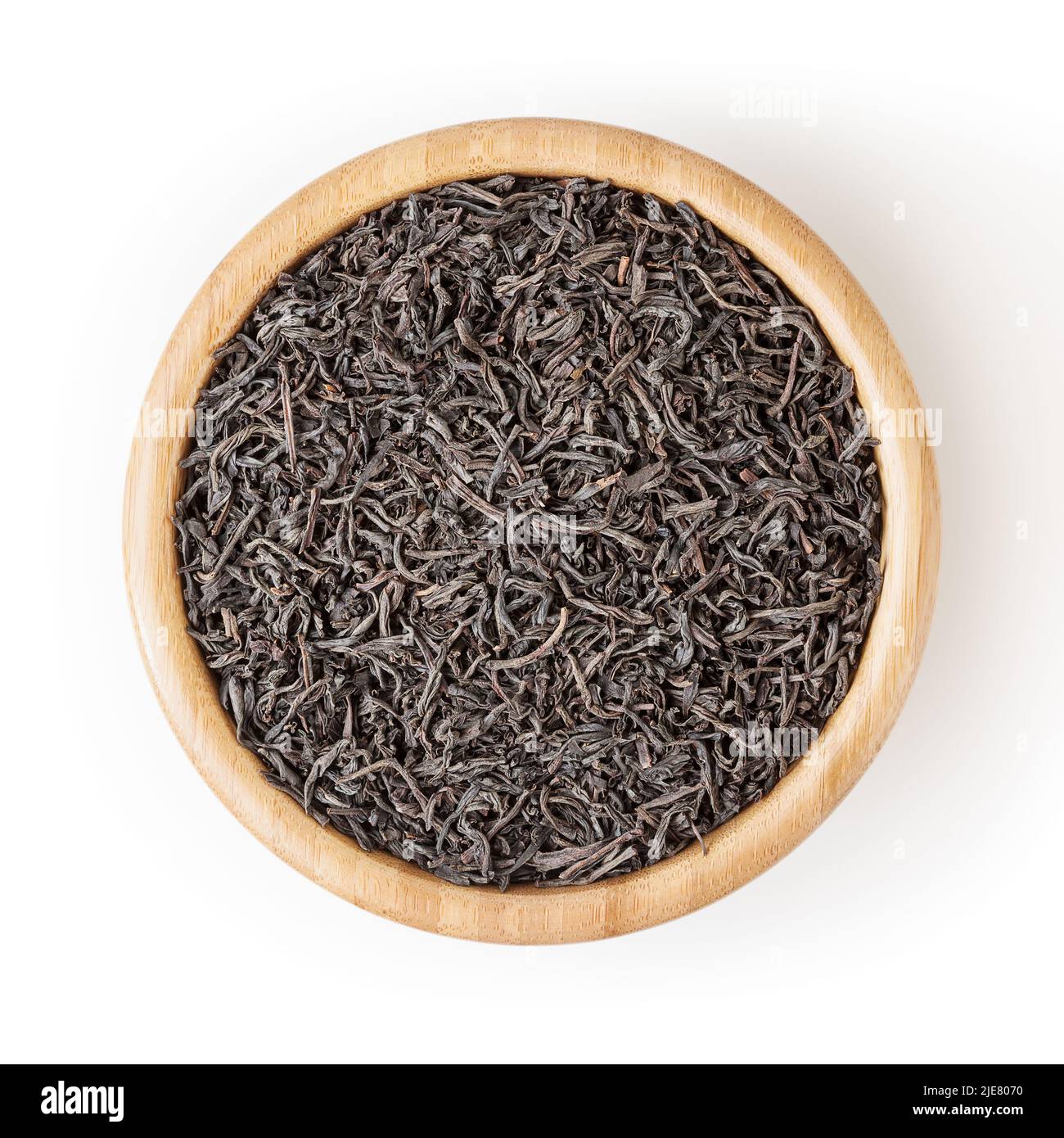 Dried black tea in wooden bowl isolated on white background with ...
