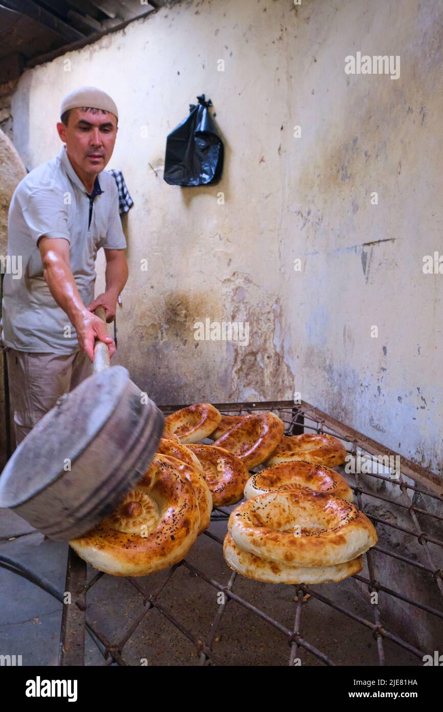 Baked non bread, fresh from the tandir oven, thrown on a wire rack for cooling. This operation is a typical small, local, hidden behind a house, set u Stock Photo