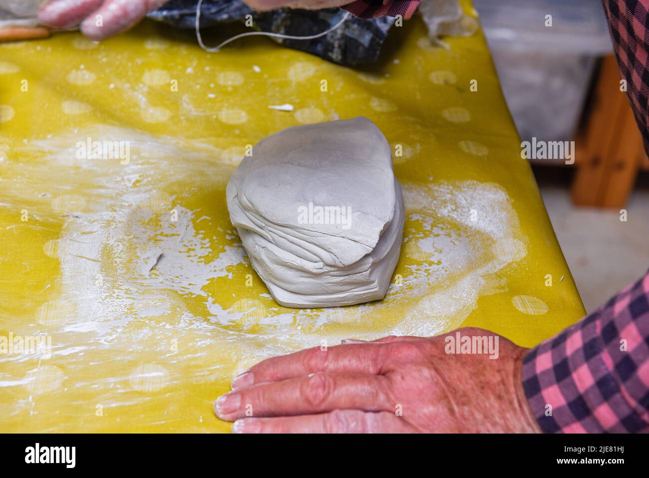 Female hands making ceramic art and pottery in a workshop class for mature people Stock Photo
