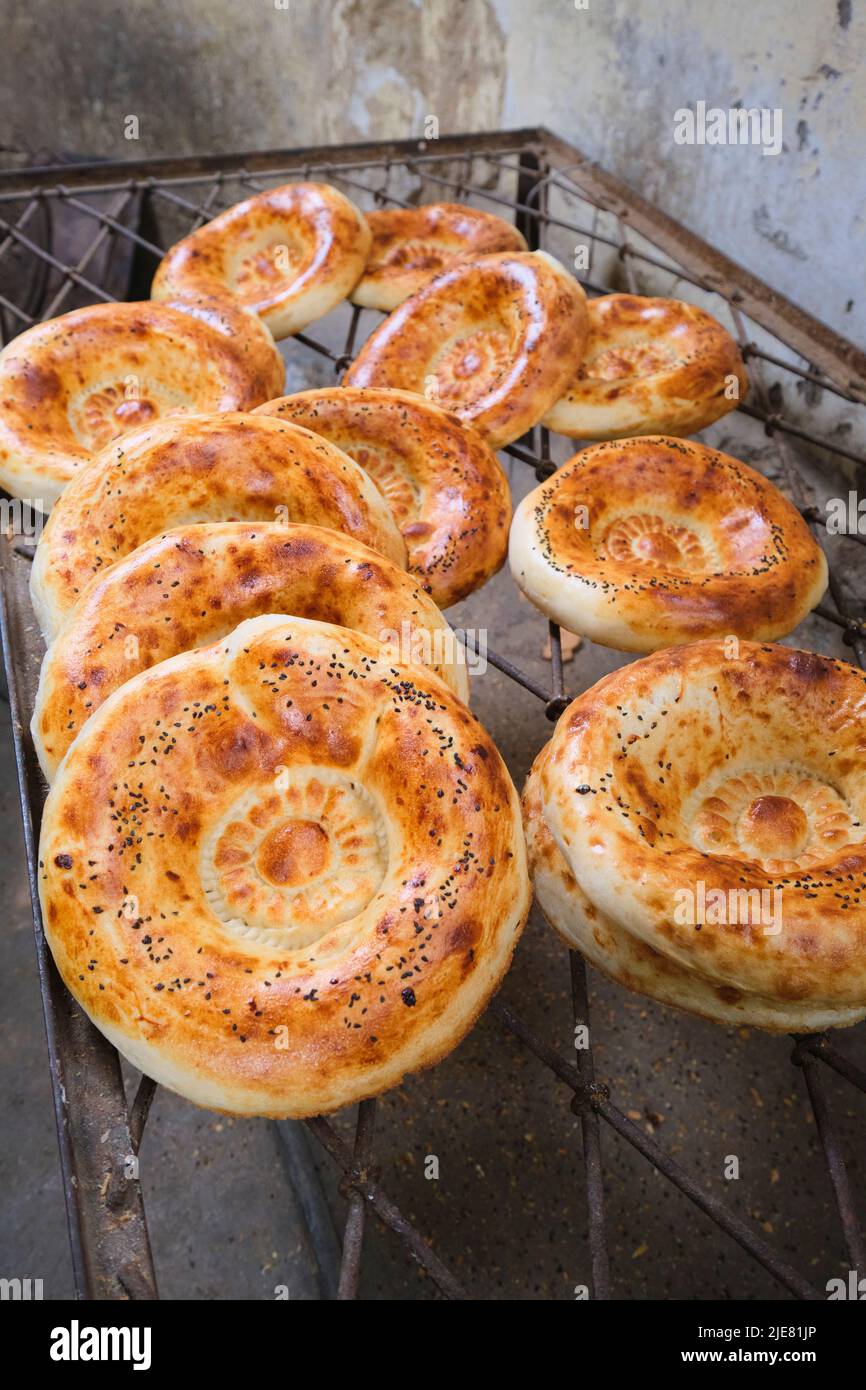 Baked non bread, fresh from the tandir oven, thrown on a wire rack for cooling. This operation is a typical small, local, hidden behind a house, set u Stock Photo