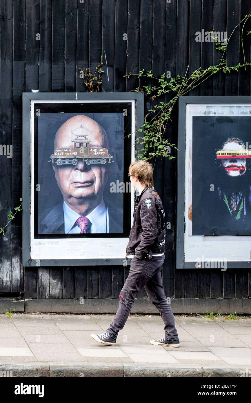 Bristol, UK. A member of the public walks past a series of framed, iconic, posters during the Bristol Upfest 2022 street art festival Stock Photo