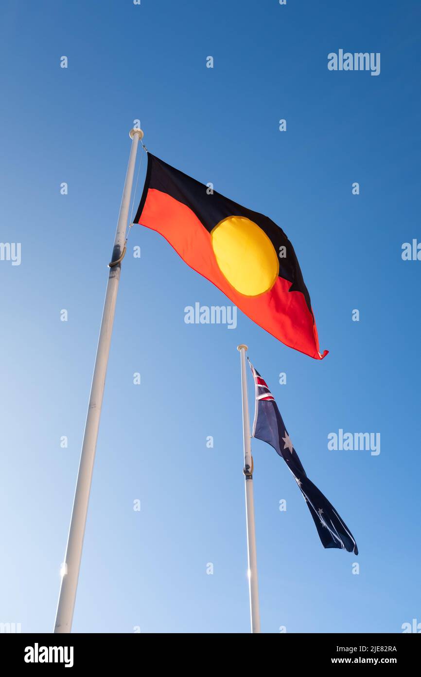 An aboriginal First Nations indigenous flag flying in front of an Australian flag Stock Photo