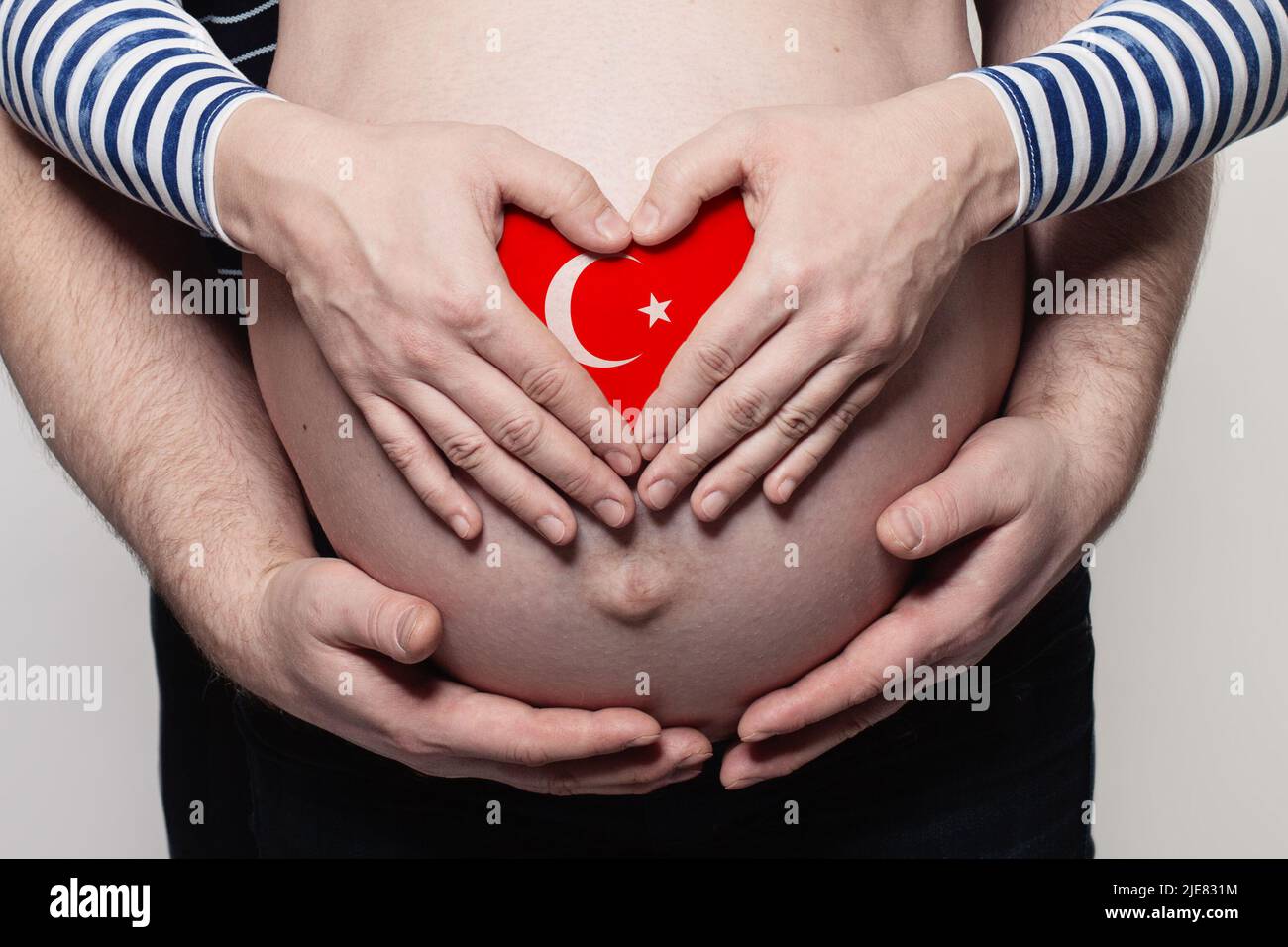 turkish-family-concept-man-embracing-pregnant-woman-belly-and-heart