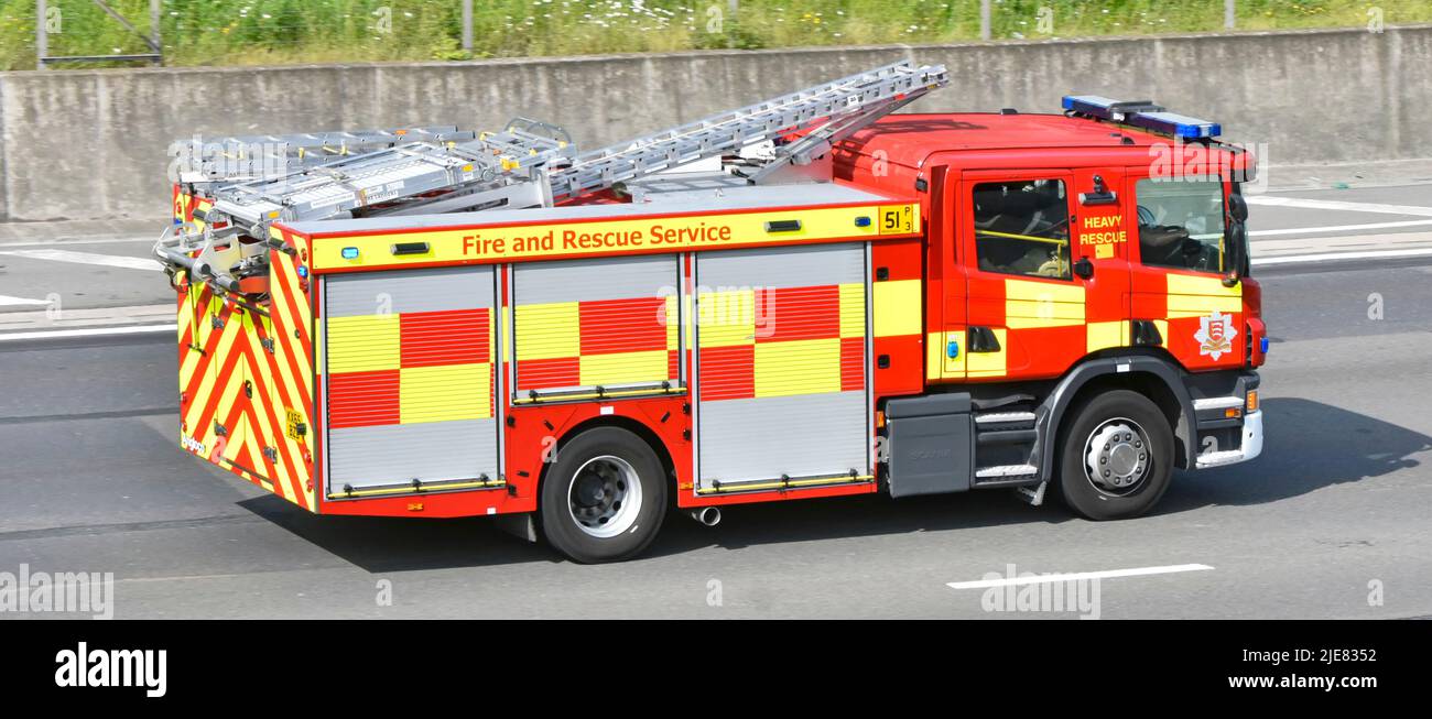 Side back view high visibility markings Essex Fire & Rescue Service fire brigade engine blue light emergency shout driving English UK motorway road Stock Photo