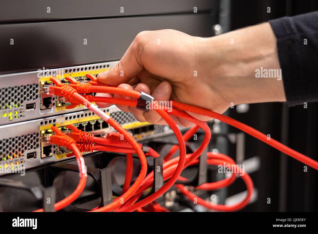 Close-up of Male Technician Plugging Cable In San Stock Photo
