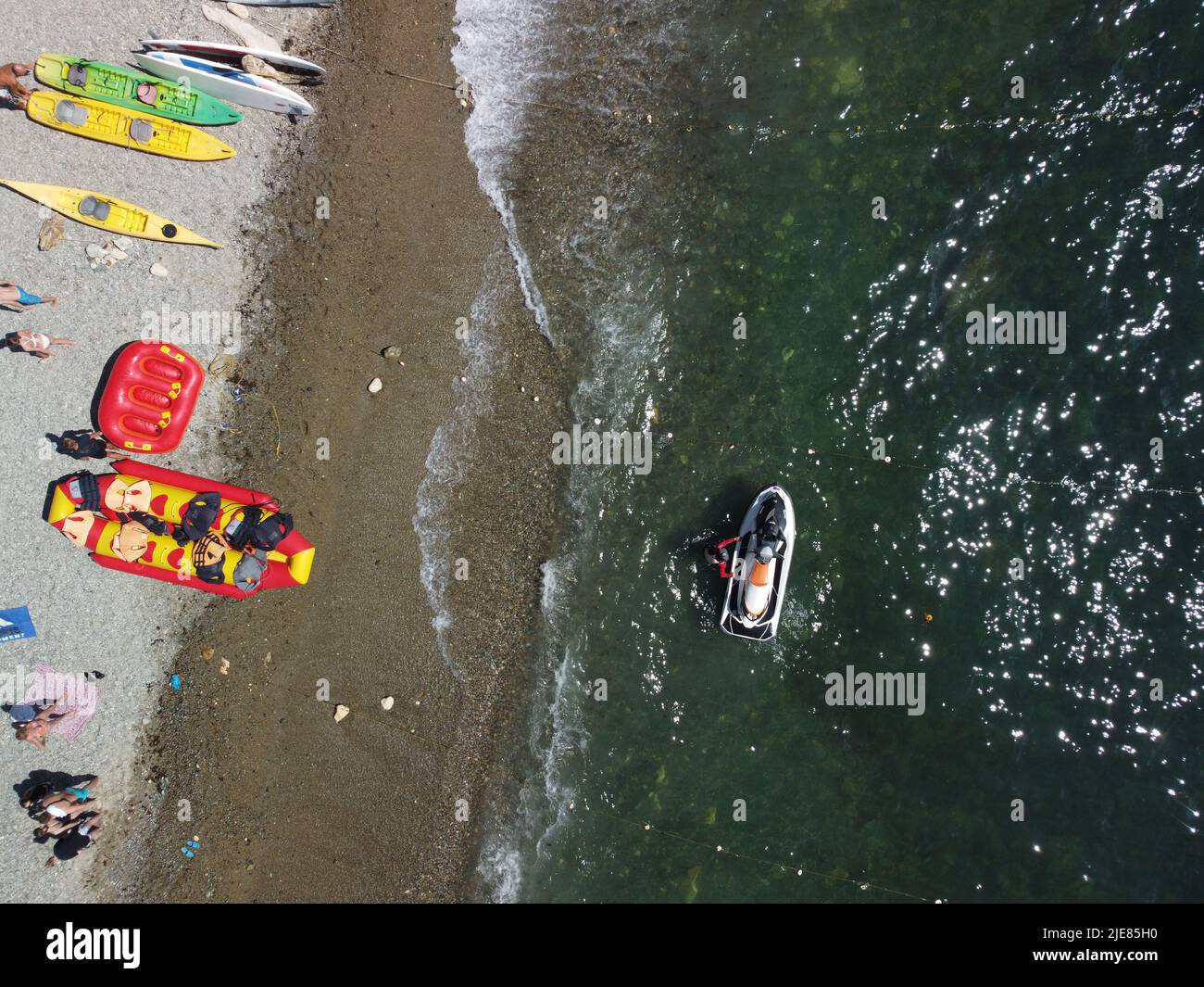 Happy people swim on air mattress behind a high speed water bike