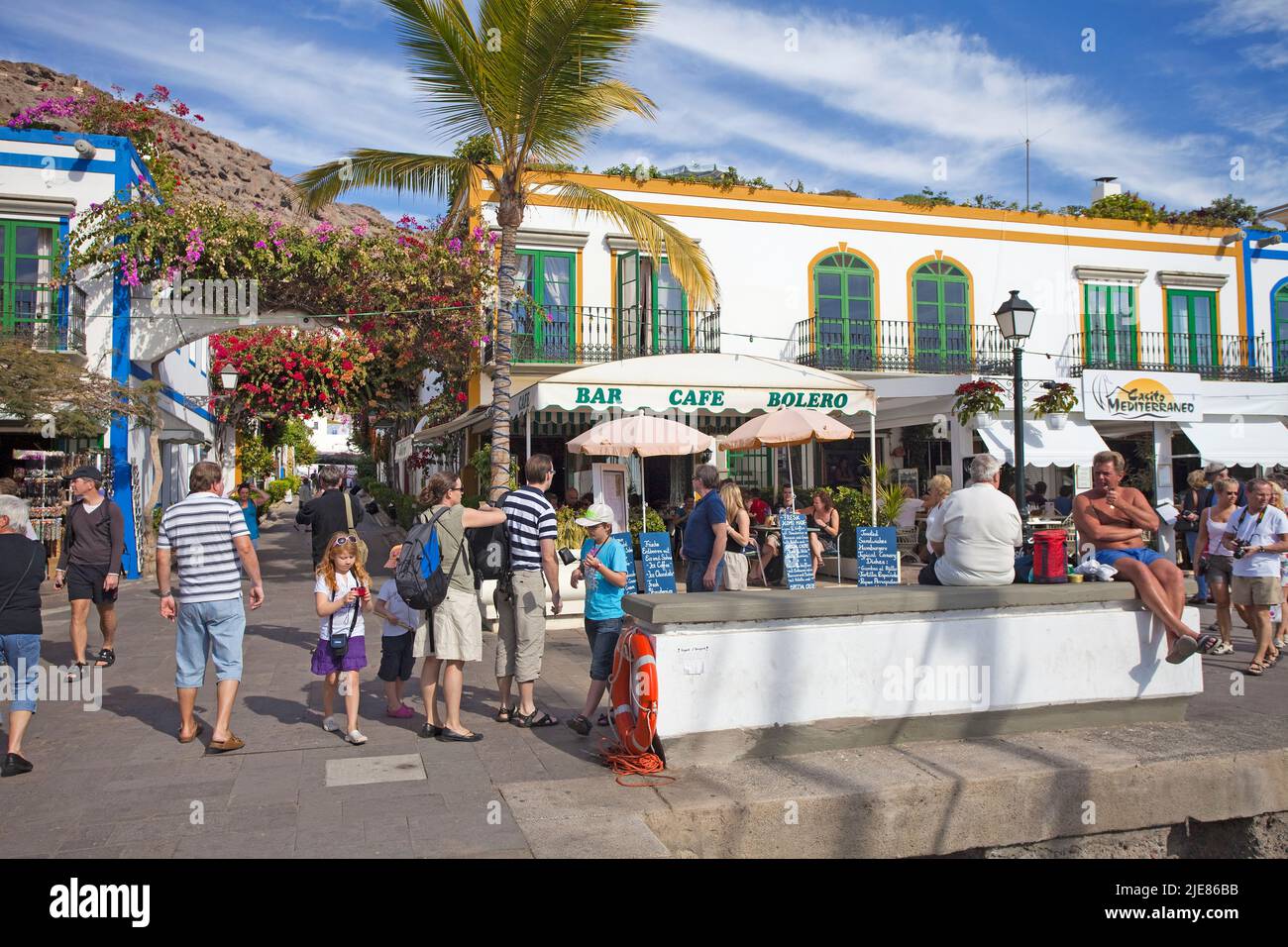 Restaurants and bars at the harbour promenade, flower decoration on arches in the alleys of Puerto de Mogan, Gran Canaria, Canary islands, Spain Stock Photo