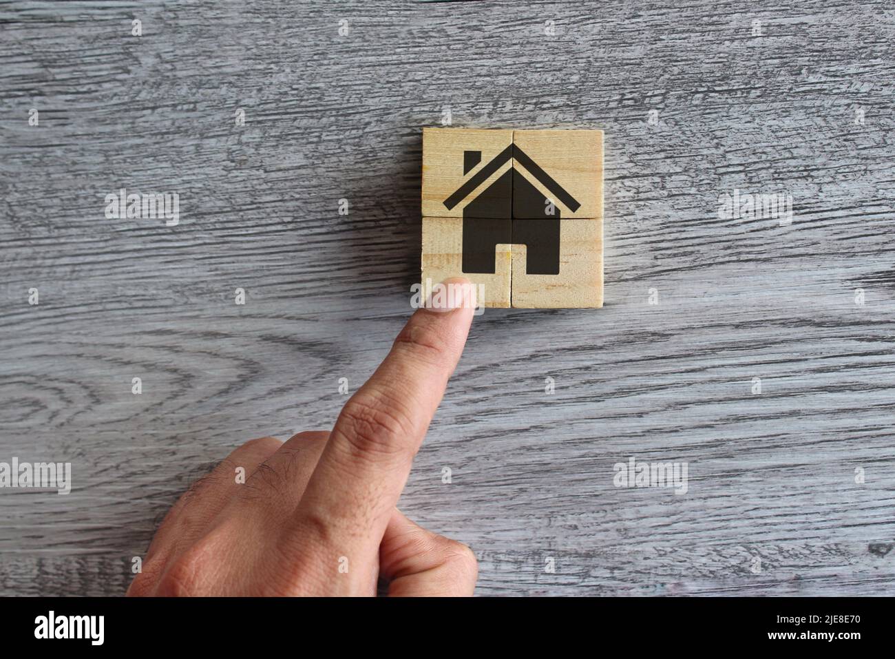 Hand put wooden cubes to make house. Build a dream house, ideal house, property concept. Stock Photo