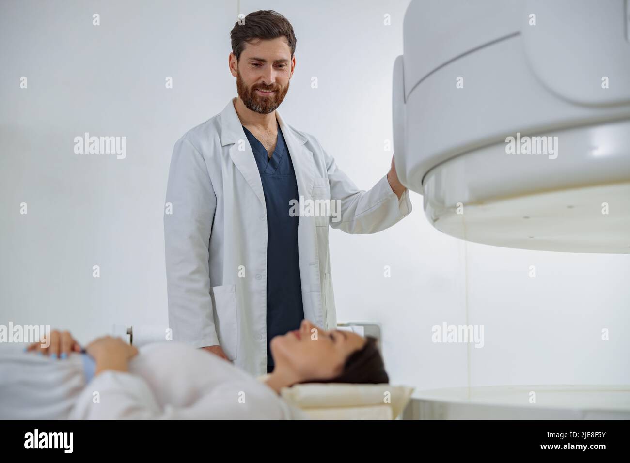 Radiologist controls MRI or CT or PET Scan with female patient