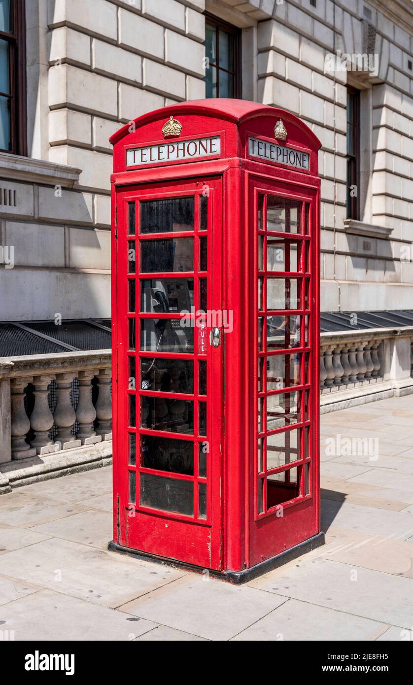 Traditional British red telephone box or telephone kiosk for a public telephone designed by Sir Gilbert Scott, in London, England, United Kingdom Stock Photo