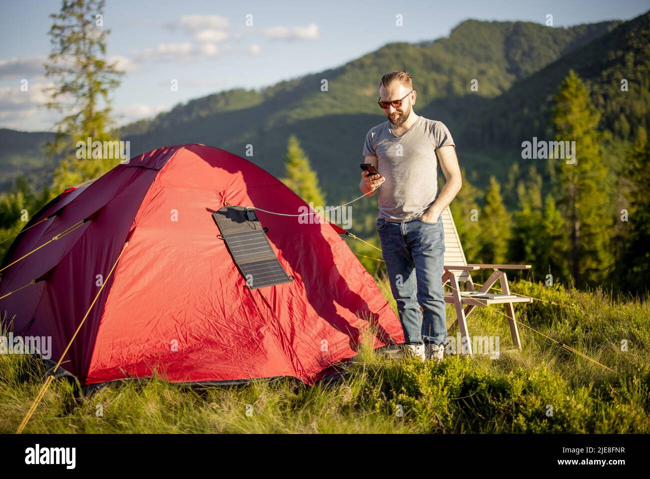 Man charges phone from solar panel while travel Stock Photo