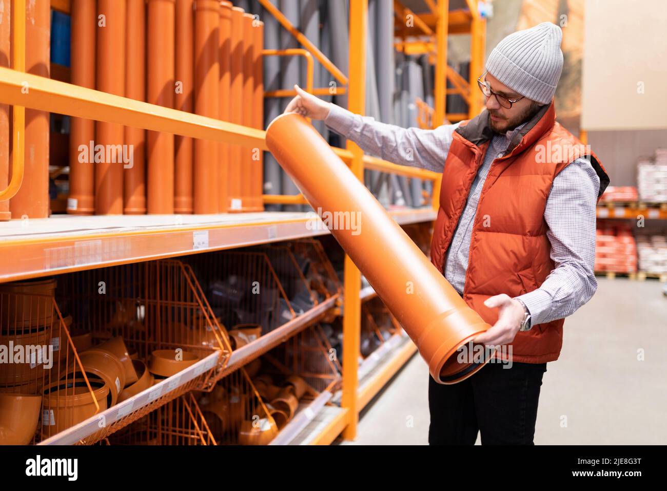 man chooses sewer pipes in a hardware store Stock Photo Alamy