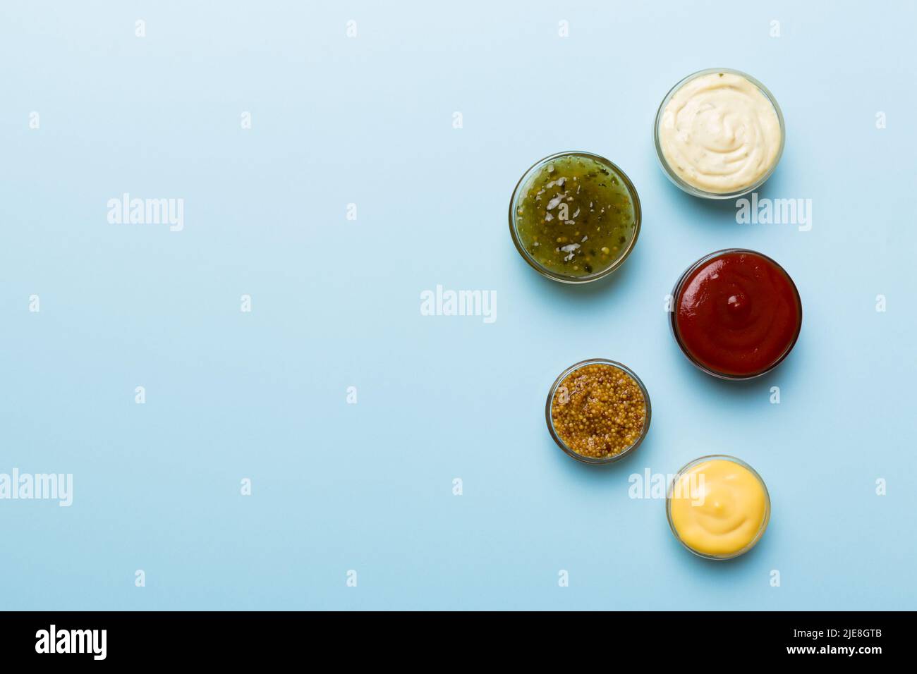 Different types of sauces in bowls on a colored Board . Top view