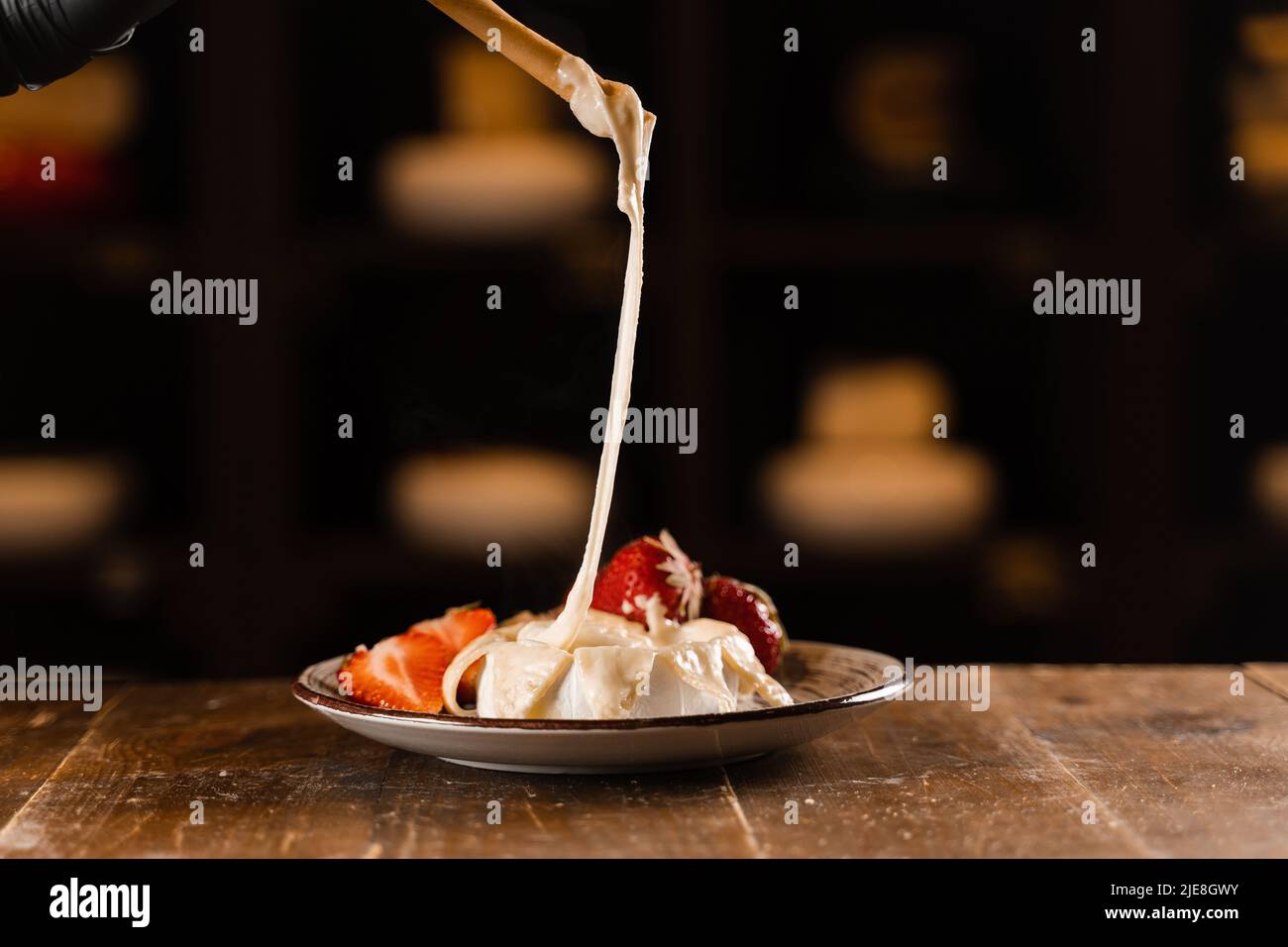 Eating hot baked brie cheese with grissini sticks. Stretching melted