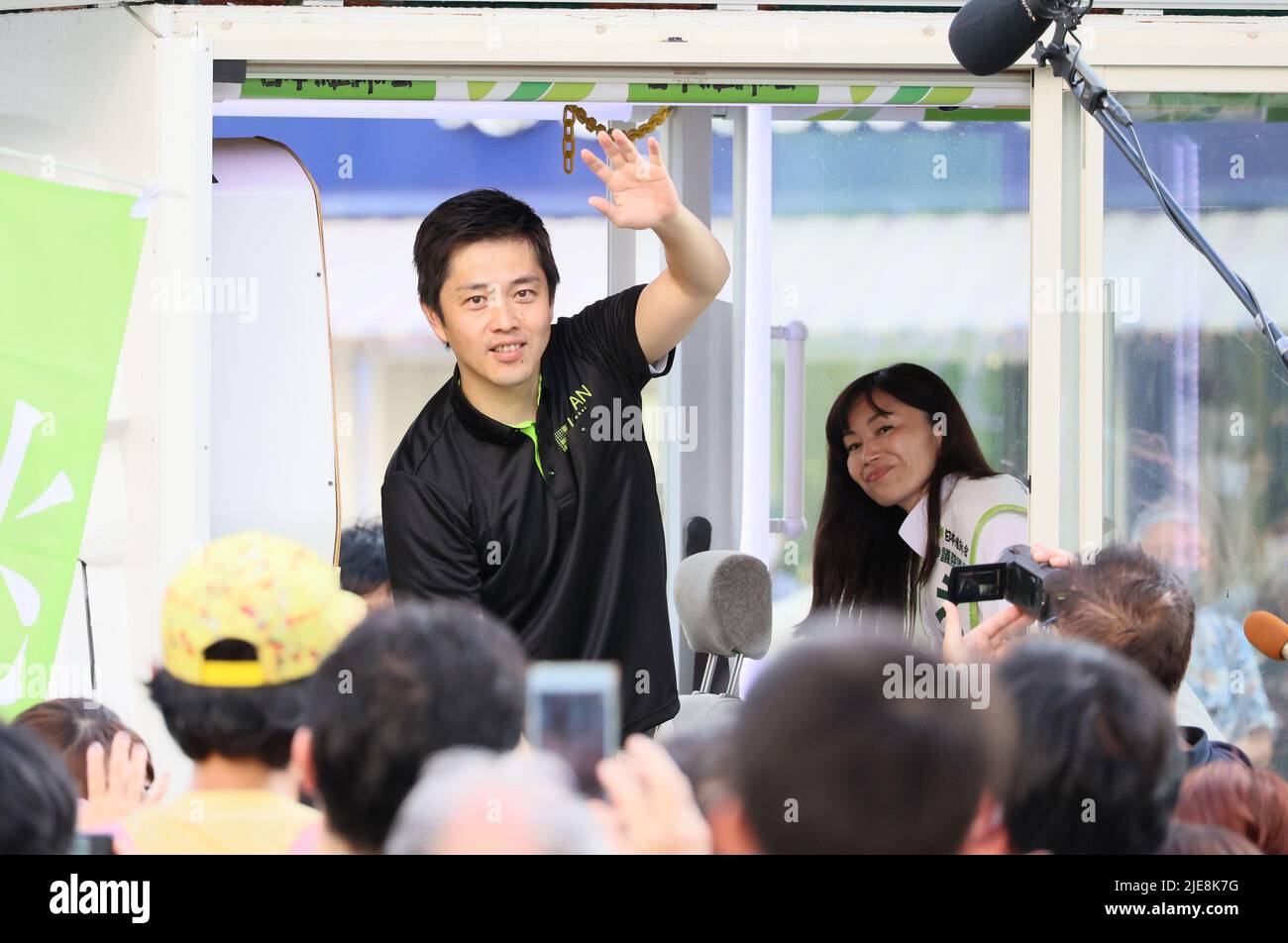 Tokyo, Japan. 26th June, 2022. Osaka Governor and deputy leader of opposition Japan Innovation Party Hirofumi Yoshimura (L) waves his hand from a vehicle with his party candidate Yuki Ebisawa (R) upon their arrival at Ginza for their campaign of the July 10 Upper House election in Tokyo on Sunday, June 26, 2022. Credit: Yoshio Tsunoda/AFLO/Alamy Live News Stock Photo