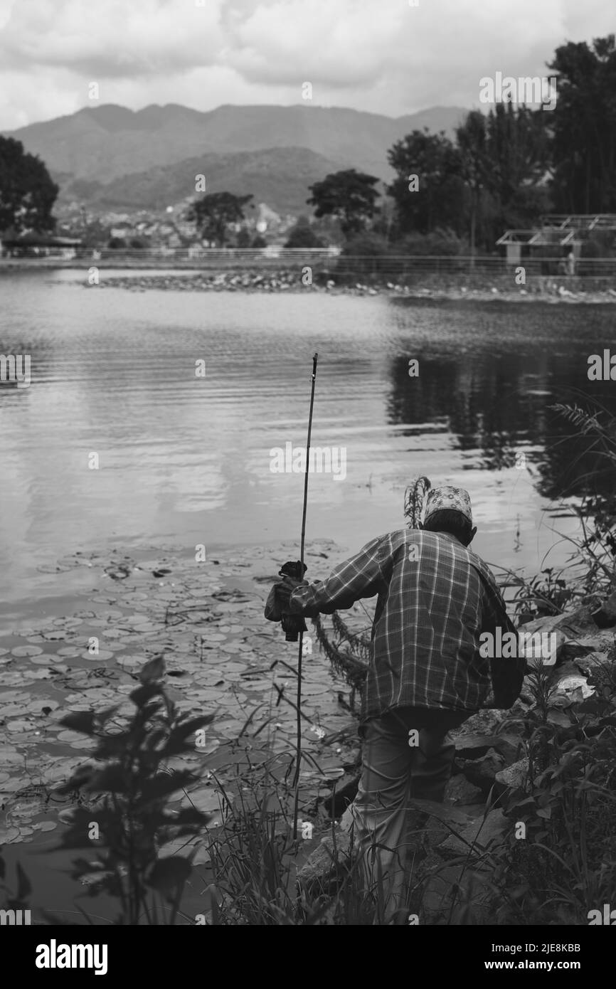 Old Man Finding a Fishing Spot in Nagdaha Lake of Nepal Stock Photo
