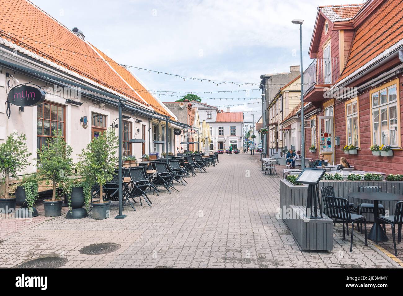 Parnu old town street with traditional houses and people sitting at the ...