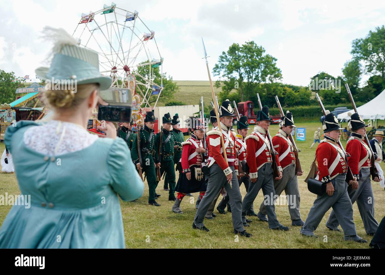 A person takes a photo as members of the 4th King's Own Regiment of Foot and 2nd Battalion 9th Rifles parade around the festival ground during the Chalke Valley History festival at Broad Chalke, Near Salisbury, Wiltshire. Picture date: Sunday June 26, 2022. Stock Photo