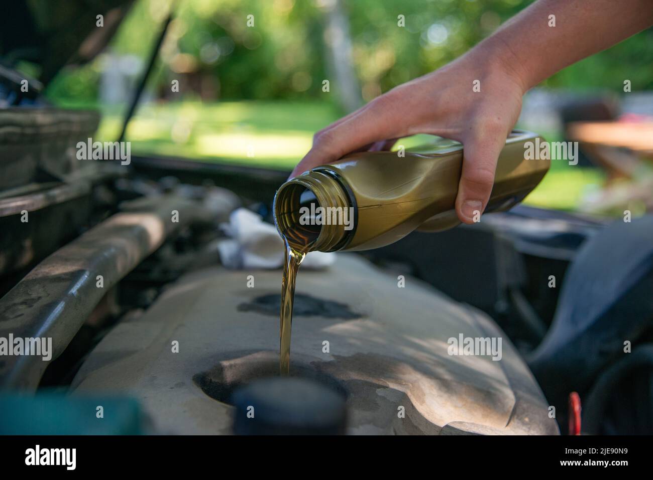 Close up hand mechanic repairing change the Oil. Car mechanic pouring