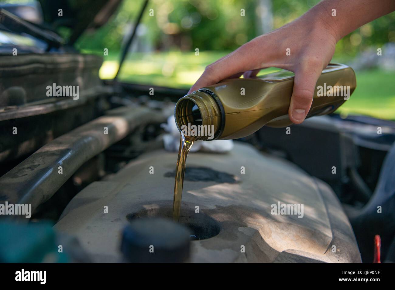 Close up hand mechanic repairing change the Oil. Car mechanic pouring