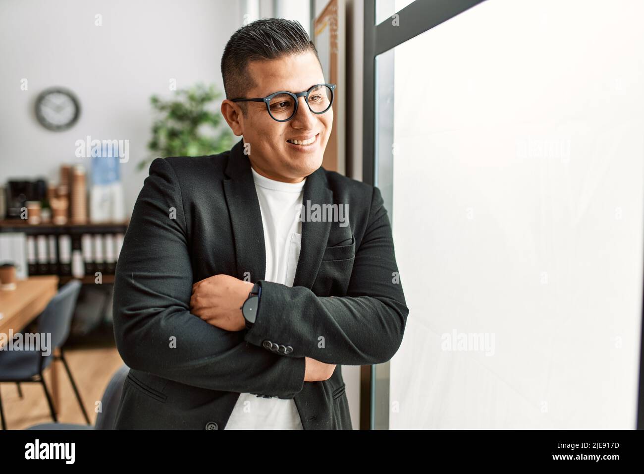 Young latin businessman smiling happy standing with arms crossed ...