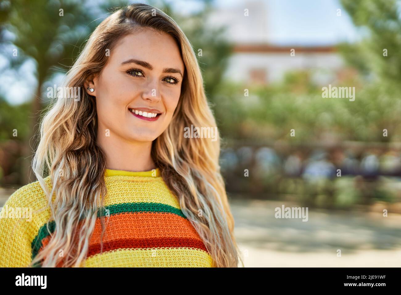 Young blonde woman smiling at the park Stock Photo - Alamy