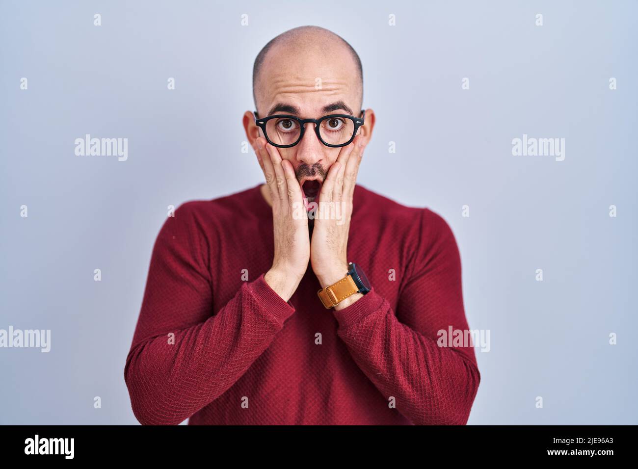 Young bald man with beard standing over white background wearing ...