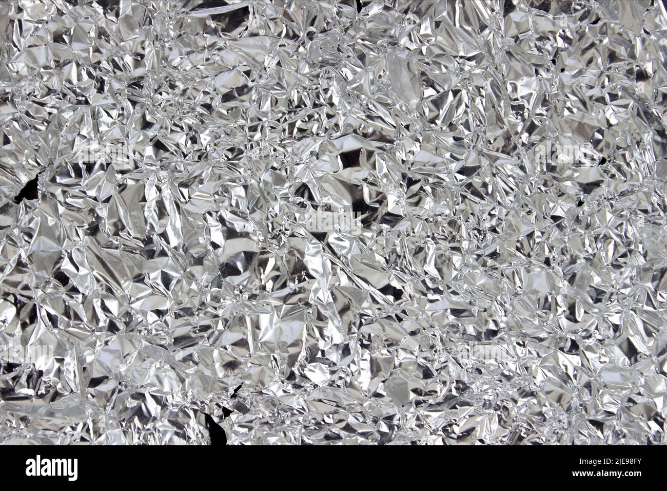 crumpled silver foil texture close up. Abstract background Stock Photo